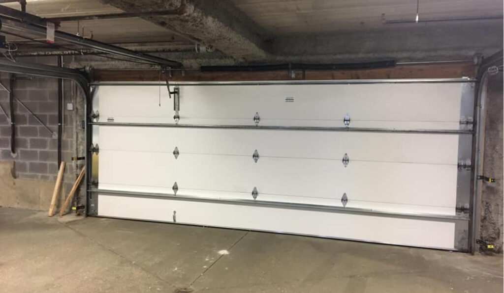 Commercial Door Solutions: overhead garage door in an underground parking lot.