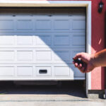 Person uses remote control to open garage door, highlighting garage safety during back-to-school family routines.