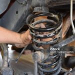 Male Hand on Spring while Working on Suspension of Vehicle