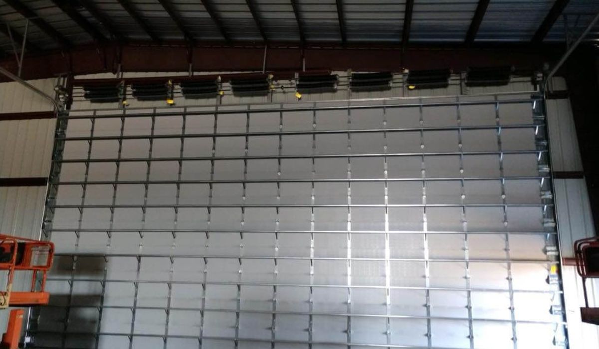 Large commercial overhead door with multiple springs and cables, showcasing extensive commercial overhead door repair.