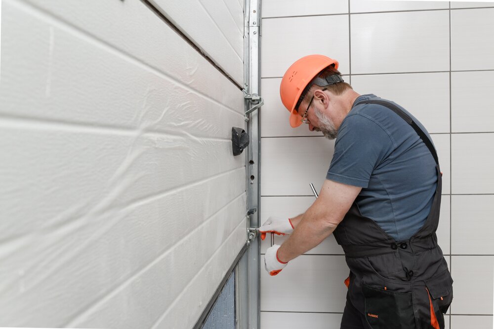 Professional technician performing a garage door tune-up, ensuring smooth operation and safety for residential properties.