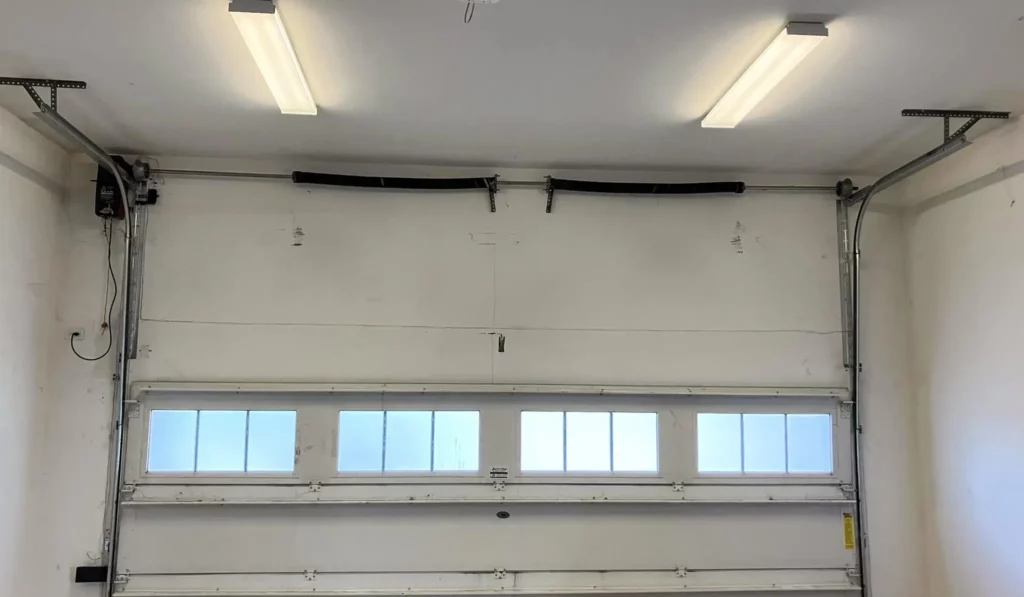 Modern trackless garage door opener installed for smooth, efficient operation in a residential garage setup.