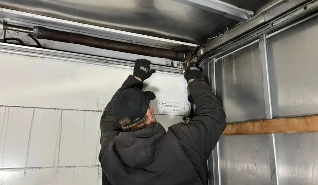 Technician performing emergency garage door repairs to ensure safe, functional operation during unexpected breakdowns or issues.