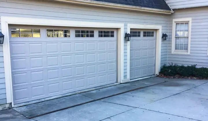 Well-maintained residential garage doors with smooth surface, highlighting importance of regular garage door maintenance for longevity.