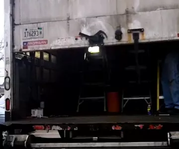Box truck roll-up door repair showing partially stuck roll-up door during on-site fleet service inspection.