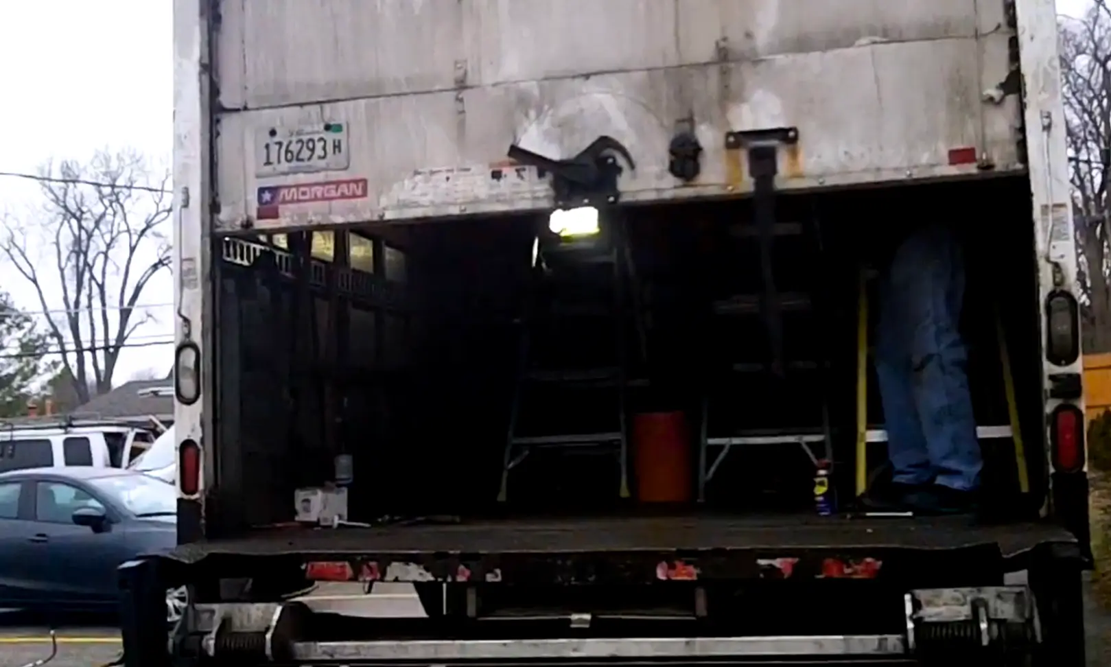 Box truck roll-up door repair showing partially stuck roll-up door during on-site fleet service inspection.